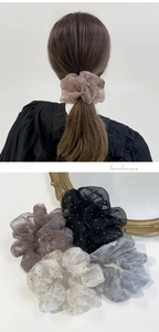 Dettaglio di elastici per capelli in tulle trasparente con paillettes in caffè, nero e crema