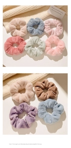 Vue détaillée de chouchous en peluche douce aux tons pastels sur fond en maille chaude