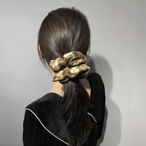 Classic checkered scrunchie with brown and yellow pattern on a ponytail style