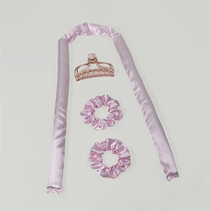 Pink satin heatless hair curler set with rollers and scrunchies on white background