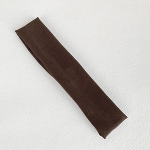Close-up of deep brown elastic knit sports headband showing fine ribbed fabric texture