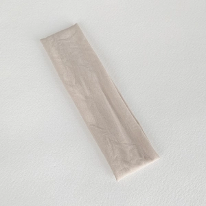 Detail of champagne elastic knitted sports headband with fine vertical ribbed texture