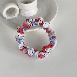 Gros plan du chouchou en tissu à motif de fruits sur un plat en céramique blanche
