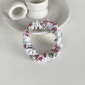Chouchou minimaliste en tissu blanc avec imprimé baies rouges et design froncé