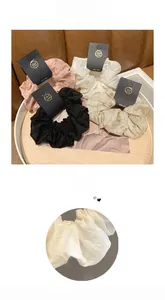 Détail de la broderie cœur sur le chouchou en satin avec carte de présentation faite main