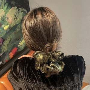 Eleganter metallisch goldener Falten-Haargummi für Damen in der Rückansicht getragen
