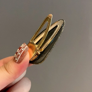 Golden metal hair clip with black textured acetate finish for women styling