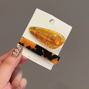 2-piece acetate hair clip set with amber and tortoiseshell patterns on display card