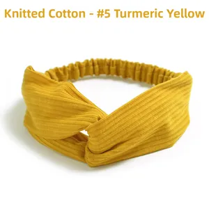Detail of ginger yellow knitted cotton headband with cross-knot design and elastic texture