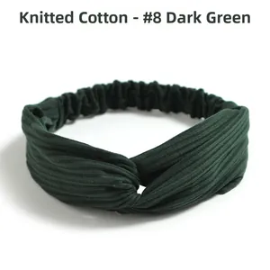 Detail of dark green ribbed knitted cotton headband with twisted front and elastic back