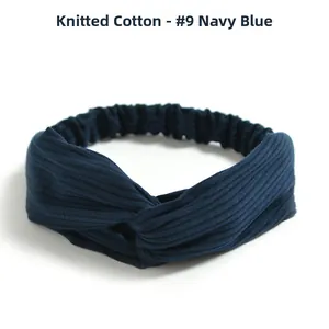 Detail of navy blue knitted cotton headband with cross knot design and ribbed texture