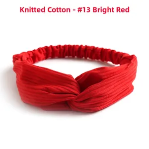 Detail of red knitted cotton headband with ribbed texture and twisted knot design