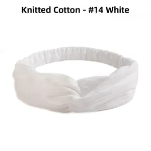 Detailed view of white knitted cotton headband with cross knot design and ribbed texture