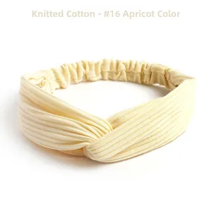 Close-up of apricot knit cotton headband featuring ribbed texture and twisted design