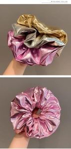 Détail de grands chouchous métalliques en argent, or et rose avec un tissu à effet plissé