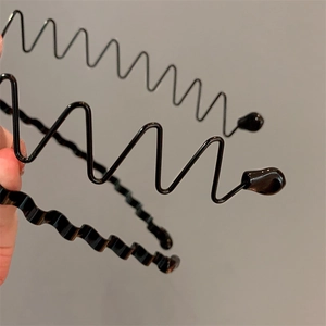 Three men's black metal wavy hairbands with smooth rubber tips in minimalist style