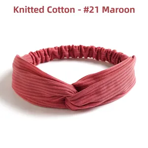 Detail of dark purple knitted cotton headband with ribbed texture and front twist design