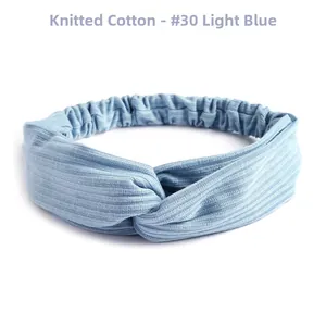 Detail view of light blue knitted cotton headband featuring twist knot and ribbed texture