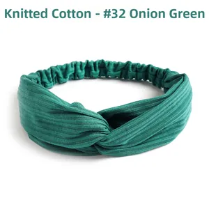 Close-up of green knitted cotton headband with cross knot and ribbed texture details