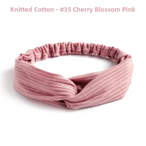 Close-up of cherry blossom pink knitted cotton headband with cross knot and ribbed texture