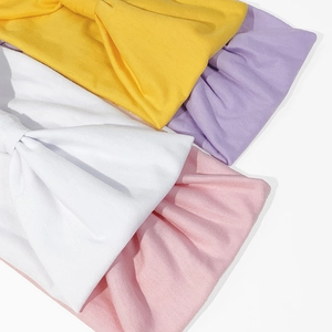 Dettaglio di fasce larghe in maglia morbida in colori giallo, viola, bianco e rosa
