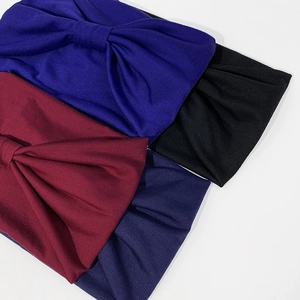 Dettaglio di fasce larghe annodate in blu reale, nero, bordeaux e blu navy a maglia