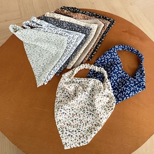 Gedetailleerd overzicht van kleurrijke elastische bloemenbandana's op een houten tafel