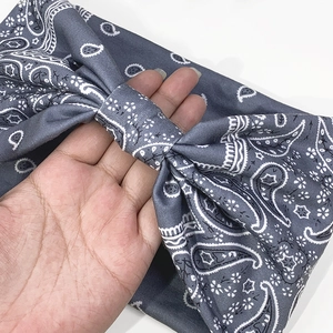Dettaglio della fascia annodata grigio scuro con motivo paisley e tessuto morbido elastico