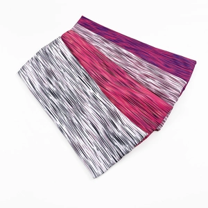 Close-up of three elastic sports headbands with colorful striped patterns on white background