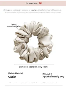 Detail view of satin hair scrunchie showing 10cm diameter and soft pleated texture