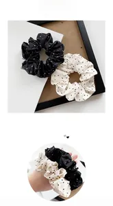 Detailed view of black and white polka dot satin scrunchies with soft fabric texture