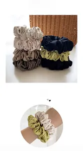 Detailed texture of high-elasticity pleated satin scrunchies in multiple earthy tones