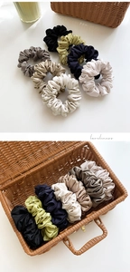 Close-up of premium satin hair scrunchies set with pleated texture and silk gloss