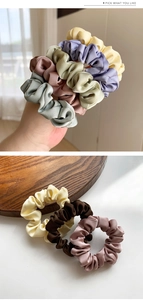Detailed macro view of soft satin silk scrunchies in various elegant muted colors