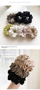 Close-up of Morandi colored satin scrunchies with pleated texture and soft silk-like sheen