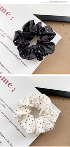 Detail of elegant black and white polka dot satin hair scrunchies with soft silk texture