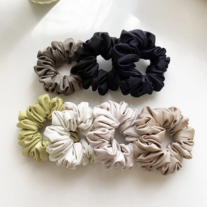 Set of seven premium satin scrunchies in various elegant colors with glossy texture