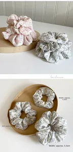 Trois tailles de chouchous à fleurs en 3,5 cm, 4 cm et 5,5 cm sur présentoir en bois