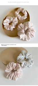 Détails de chouchous à fleurs en mousseline rose et bleue sur un support en bois