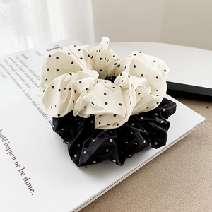 French style polka dot satin scrunchie set in black and white on a lifestyle magazine