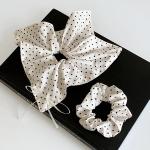 Lot de chouchous à pois avec nœud et ruban sur un livre pour un style doux