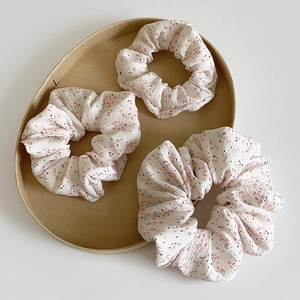 Lot de chouchous à fleurs roses sur tissu beige pour des coiffures fraîches et chics