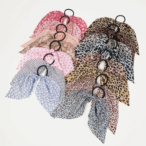 Detailed flat lay of 12 chiffon leopard and floral hair scrunchies with long ribbons
