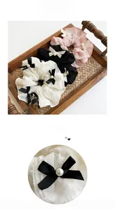 Detail of lace scrunchies with elegant bows and pearls in white, black and pink colors