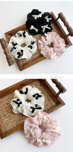 Lace scrunchies set with ribbon bows and pearls in black, white, and pink colors