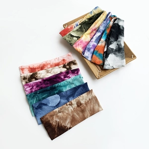 Bandeaux de yoga extensibles tie-dye aux couleurs variées dans un panier en bois