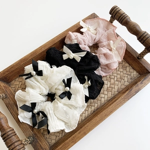 Three-piece lace scrunchie set with satin bows and pearls in black, white, and pink