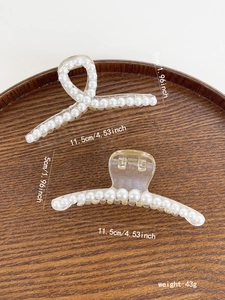 Detailed view of pearl hair claw clips on wood tray with measurements 11.5cm by 5cm