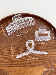 Three clear acrylic hair claws showing 11cm large size dimensions on wood tray