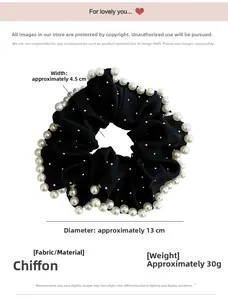Detail shot of black chiffon scrunchie with white faux pearls and silver rhinestones